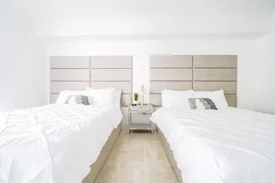 two beds in a bedroom with white sheets at LuxBright 1BR Brickell Paradise with Oceanview and Parking in Miami