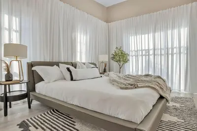 a white bedroom with a large bed with white curtains at Stunning 2 Story Villa with Pool in Fort Lauderdale