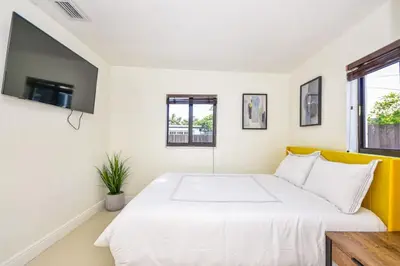 a bedroom with a white bed and a tv at Five Bedroom Villa With POOL In Highland Lakes Near Aventura Mall in Miami