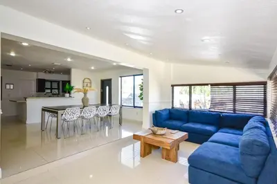 a living room with a blue couch and a table at Five Bedroom Villa With POOL In Highland Lakes Near Aventura Mall in Miami