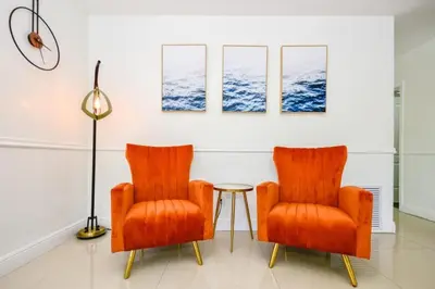 two orange chairs and a table in a room at Five Bedroom Villa With POOL In Highland Lakes Near Aventura Mall in Miami