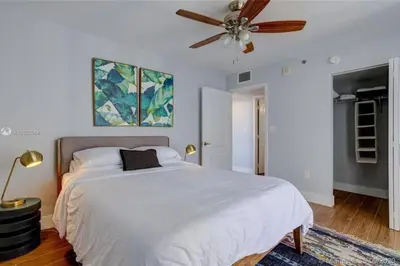 a bedroom with a white bed with a ceiling fan at 3BR Airbnb Friendly Condo with Ocean View and Balcony in Miami