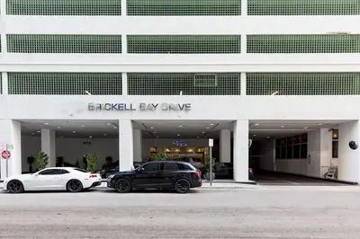 two cars parked in a parking lot in front of a building at 3BR Airbnb Friendly Condo with Ocean View and Balcony in Miami