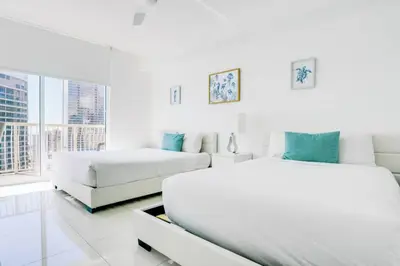 a white bedroom with two beds and a couch at Penthouse with Ocean and City Views in Lux Miami Brickell Sleeps 4 in Miami