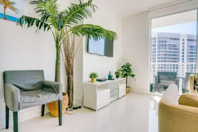 a living room with a chair and palm trees at Penthouse with Ocean and City Views in Lux Miami Brickell Sleeps 4 in Miami