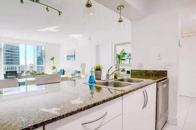a white kitchen with a sink and a counter top at Penthouse with Ocean and City Views in Lux Miami Brickell Sleeps 4 in Miami