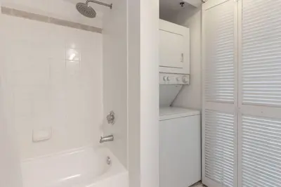 a white bathroom with a shower and a sink at Sunshine Ocean and City Views 1 BR Paradise with Parking in Miami
