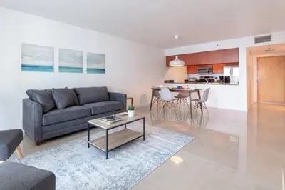 a living room with a couch and a table at Sunshine Ocean and City Views 1 BR Paradise with Parking in Miami
