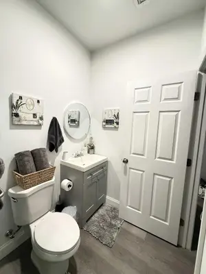 a white bathroom with a toilet and a sink at Modern Miami Retreat, Hot Tub and Gazebo Oasis in Miami