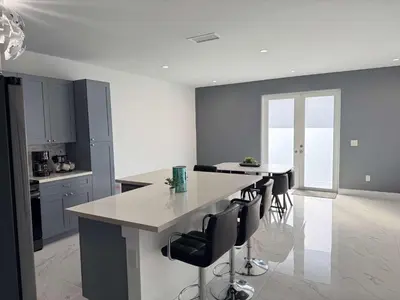 a kitchen with a large island with black chairs at Modern Miami Retreat, Hot Tub and Gazebo Oasis in Miami