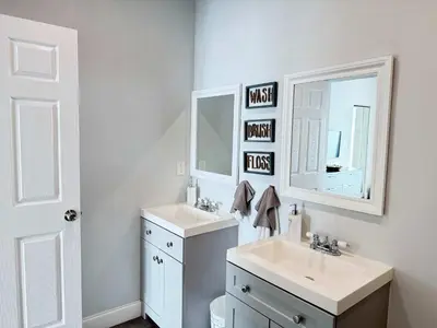 a bathroom with two sinks and two mirrors at Modern Miami Retreat, Hot Tub and Gazebo Oasis in Miami