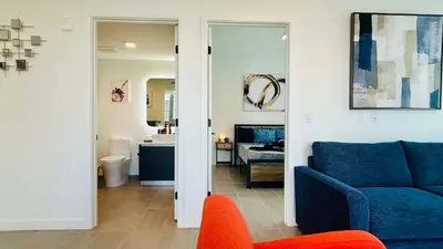 a living room with a blue couch and a bedroom at Sky-High oasis heated Pool & Gym Miami Skyline Vista in Miami