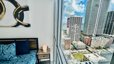 a bedroom with a window with a view of a city at Sky-High oasis heated Pool & Gym Miami Skyline Vista in Miami