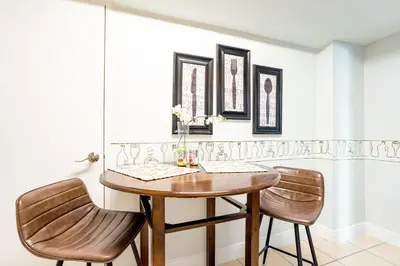 a dining room with a wooden table and two chairs at Beachfront 1-Bedroom Apartment with Ocean View, Pool and Gym in Hollywood Beach in Hollywood