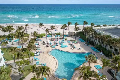 an aerial view of a resort pool and the beach at Beachfront 1-Bedroom Apartment with Ocean View, Pool and Gym in Hollywood Beach in Hollywood