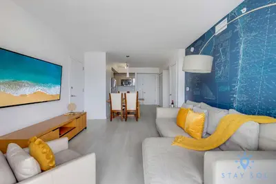 a living room with a couch and a tv at Infinite View Balcony with Pool, Gym and Near Beach in Hallandale Beach