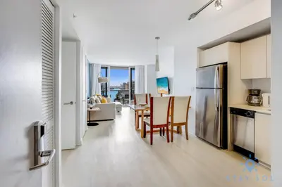 a kitchen and dining room with a table and chairs at Infinite View Balcony with Gym, Pool and Near Beach in Hallandale Beach