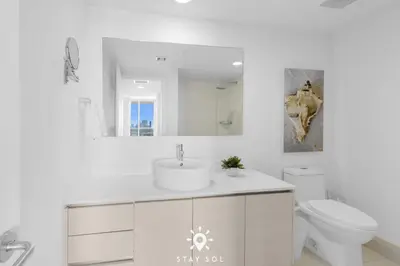 a white bathroom with a sink and a toilet at Balcony with View, Pool, Gym, Near Beach in Hallandale Beach