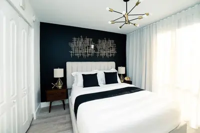 a bedroom with a white bed and a black wall at City views at brickell miami in Miami