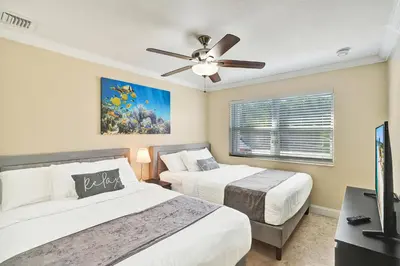 a bedroom with two beds and a ceiling fan at Deluxe Home Heated Pool & Jetted Tub near Beach in Dania Beach