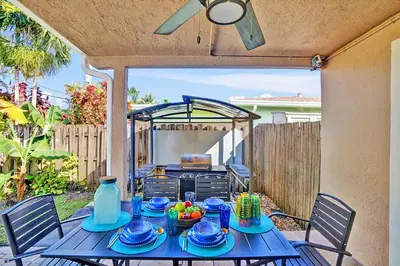 a table with blue dishes on it in a backyard at Deluxe Home Heated Pool & Jetted Tub near Beach in Dania Beach
