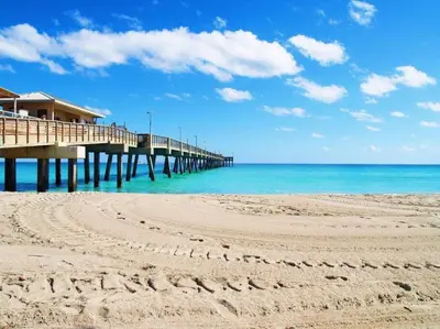 a pier on a beach next to the ocean at Deluxe Home Heated Pool & Jetted Tub near Beach in Dania Beach