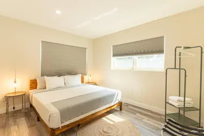 a bedroom with a large bed and two windows at Oia House Brickell Beach 10 minutes Pool Location in Miami