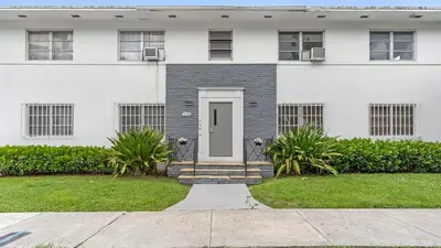 a white house with a white door and a yard at Brickell Tree Apartment Beach 10min Location Shops in Miami