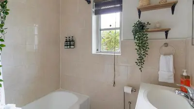 a bathroom with a tub and a sink and a window at Brickell Tree Apartment Beach 10min Location Shops in Miami