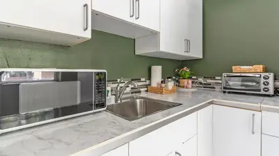 a kitchen with white cabinets and a stainless steel sink at Brickell Tree Apartment Beach 10min Location Shops in Miami