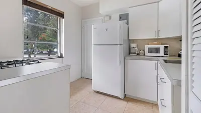 a kitchen with white cabinets and a white refrigerator at Brickell 4ever Apartment Beach 10 minutes Location in Miami