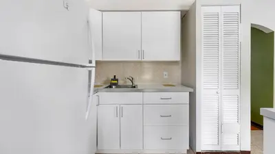 a white kitchen with a sink and a refrigerator at Brickell 4ever Apartment Beach 10 minutes Location in Miami