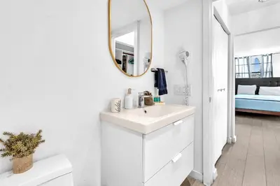 a white bathroom with a sink and a mirror at Deluxe modern 1 bedroom in south beach in Miami Beach