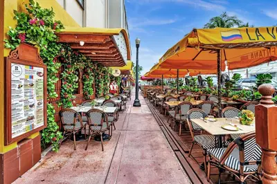 an outdoor restaurant with tables and chairs and an umbrella at Deluxe modern 1 bedroom in south beach in Miami Beach