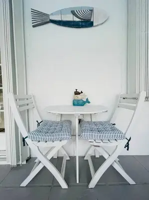 a white table and two chairs with a table and a cat on it at Home in Miami in Miami