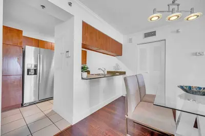 a kitchen with a stainless steel refrigerator and a chair at Central ocean view 3 bedrooms in Miami W Parking in Miami