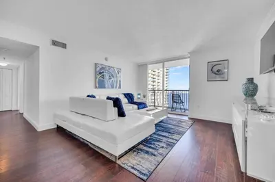 a white living room with a white couch and blue pillows at Central ocean view 3 bedrooms in Miami W Parking in Miami