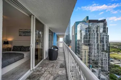 a balcony with a bed and a view of a city at Iconic High floor 3 bedrooms in the heart of Miami in Miami