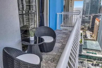 a balcony with two chairs and a table on a building at Iconic High floor 3 bedrooms in the heart of Miami in Miami