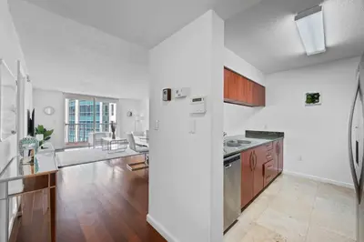 a kitchen with a refrigerator and a living room at Superb unit, centrally located with parking in Miami