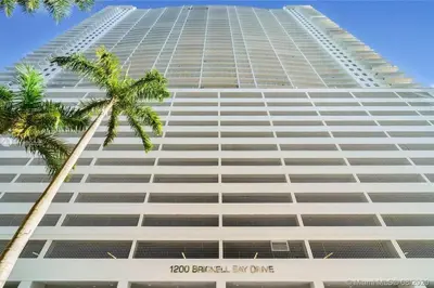 a tall building with a palm tree in front of it at Spacious Ocean view unit in the heart of Brickell in Miami