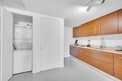 a kitchen with white appliances and wooden cabinets at Emblematic unit at Icon in the heart of Brickell in Miami