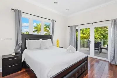 a bedroom with a large bed and a balcony at Hollywood Luxurious Waterfall Villa with Incredible views in Hollywood