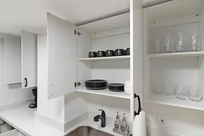 a kitchen with white cabinets and a sink at Roami at The Alamac in Miami Beach