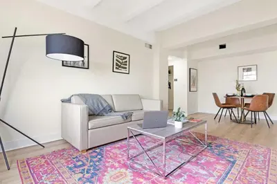 a living room with a couch and a table with a laptop at Roami at The Alamac in Miami Beach