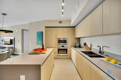 a large kitchen with wooden cabinets and appliances at Insane Ocean View Balcony Beachfront Resort Pool in Hollywood