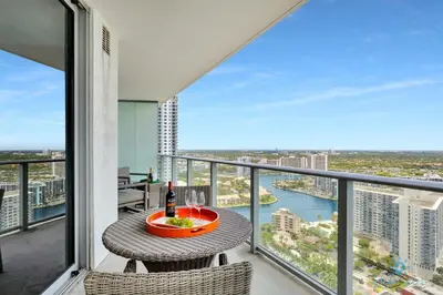 a balcony with a table with a bottle of wine at Insane Ocean View Balcony Beachfront Resort Pool in Hollywood