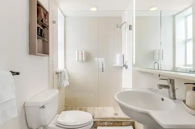 a white bathroom with a toilet and a sink at Aloha Fridays in Miami Beach