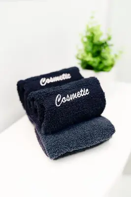 two black towels sitting on a counter with a plant at Franklin Suites South Beach in Miami Beach