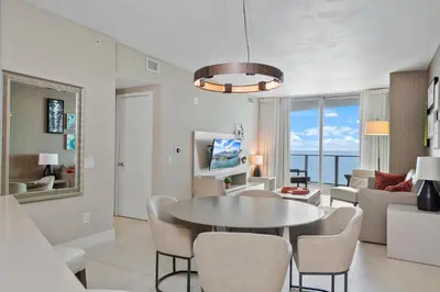 a dining room and living room with a table and chairs at 15th-Floor Luxury 1BR at Lyfe Resort with Ocean View in Hollywood